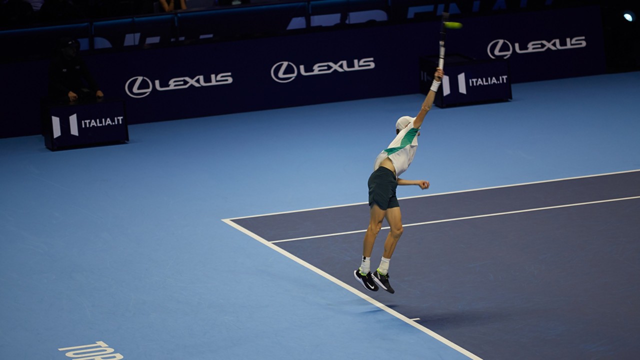 A tennis player serving on a Lexus X ATP court